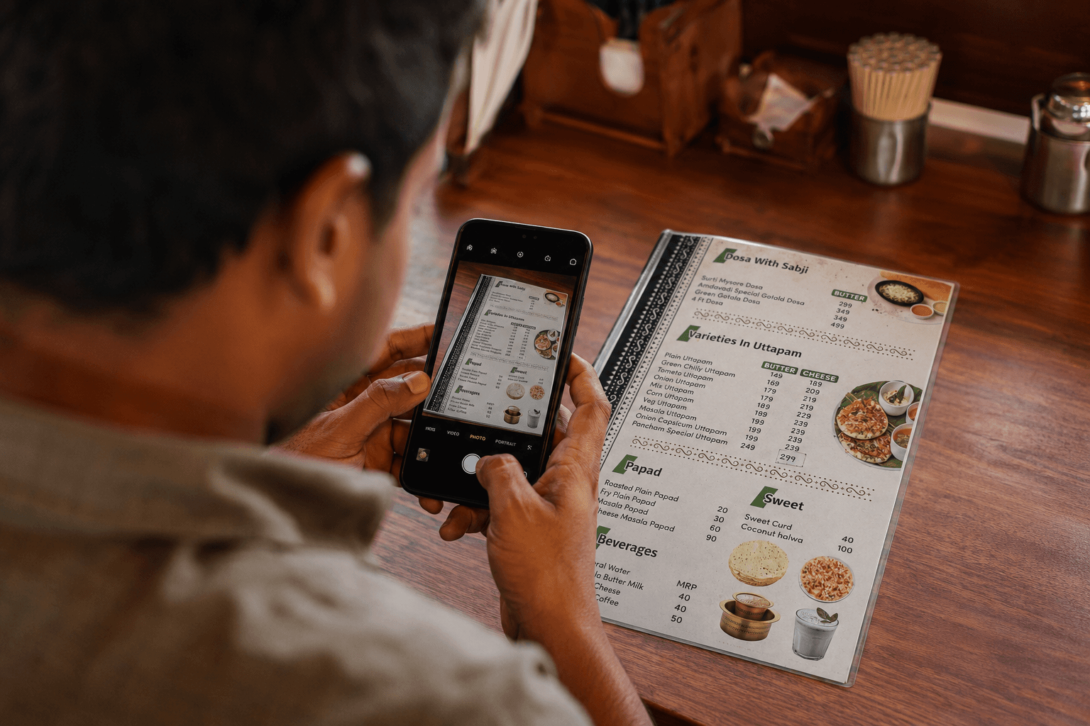 Photographing a paper menu with a phone at a food counter